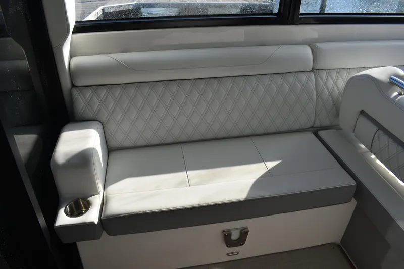 Slide: The Image of 2024 Regal 36 XO boat interior with luxurious white leather seating and cup holder. - 19