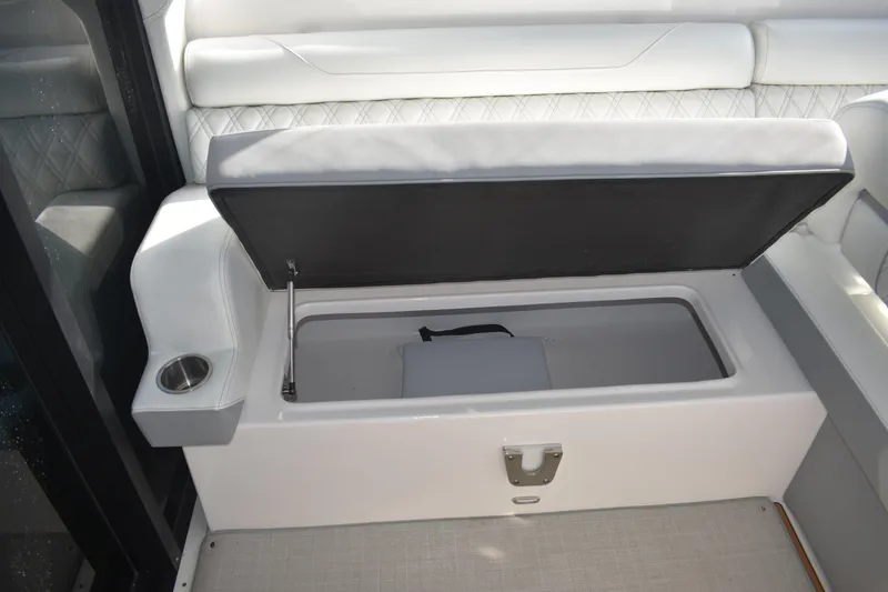 Slide: The Image of 2024 Regal 36 XO boat interior with open storage compartment and cup holder. - 20