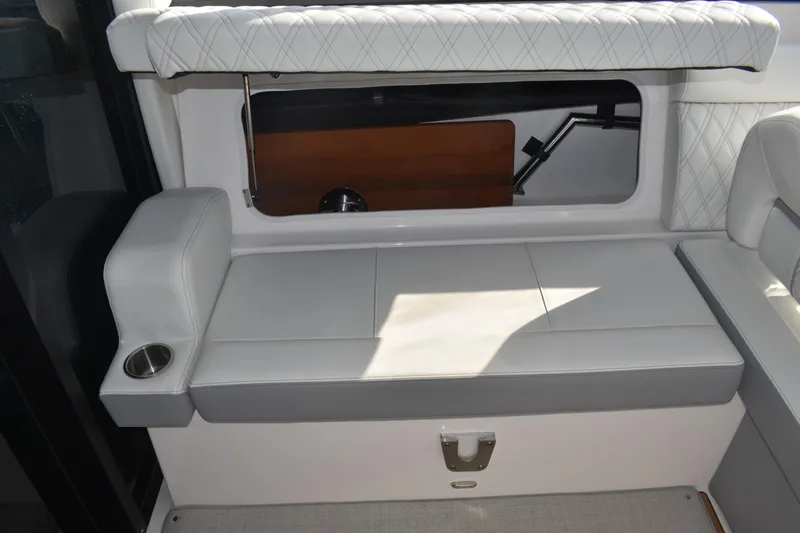 Slide: The Image of 2024 Regal 36 XO boat interior with white cushioned seating and cup holder. - 21