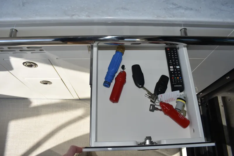 Slide: The Image of Open drawer in 2024 Regal 36 XO yacht with keys and remote control. - 28