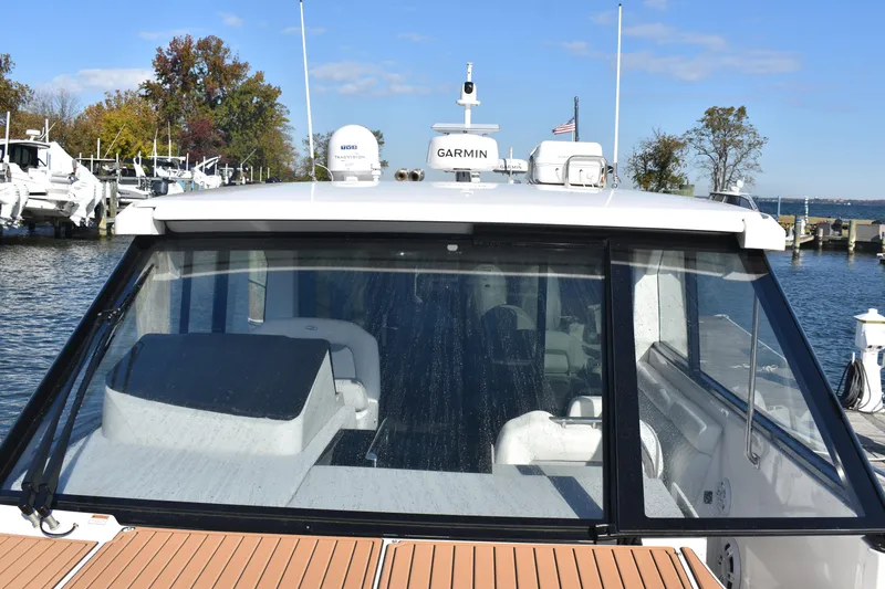 Slide: The Image of 2024 Regal 36 XO boat with Garmin navigation, docked at a marina. - 46