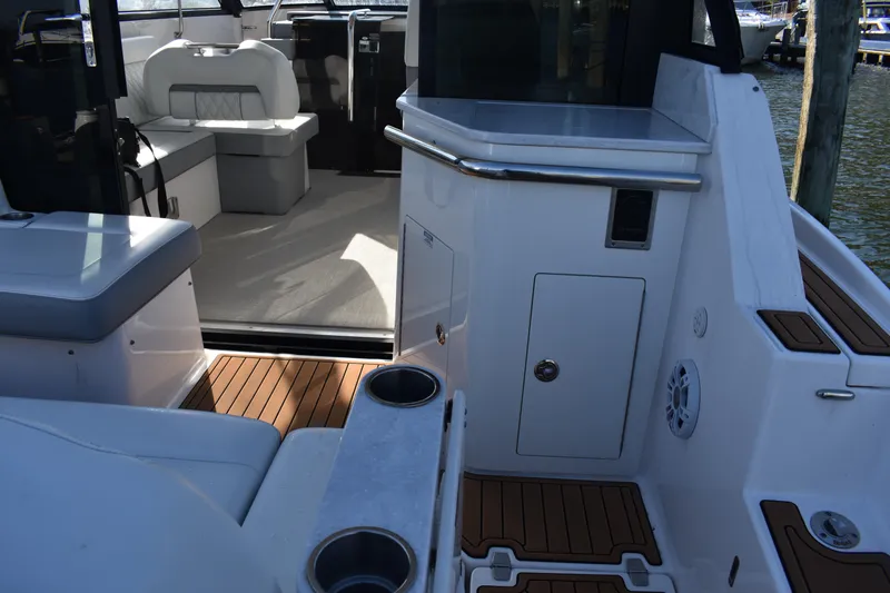Slide: The Image of 2024 Regal 36 XO boat interior with seating and wood flooring, docked at marina. - 5