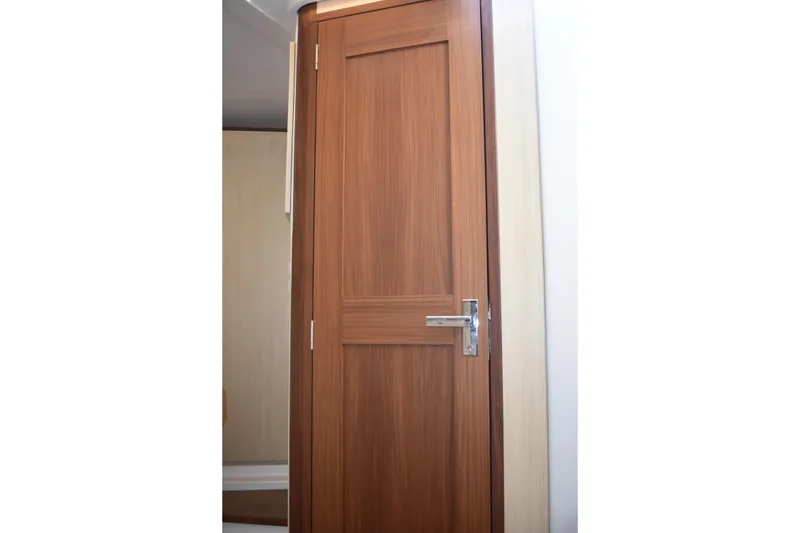 Slide: The Image of Wooden cabin door inside 2024 Regal 36 XO yacht, featuring sleek design and modern handle. - 51