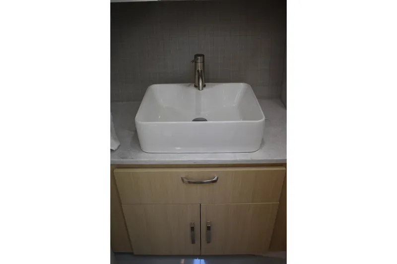 Slide: The Image of Modern bathroom sink on Regal 36 XO 2024 yacht, featuring sleek design and cabinetry. - 55