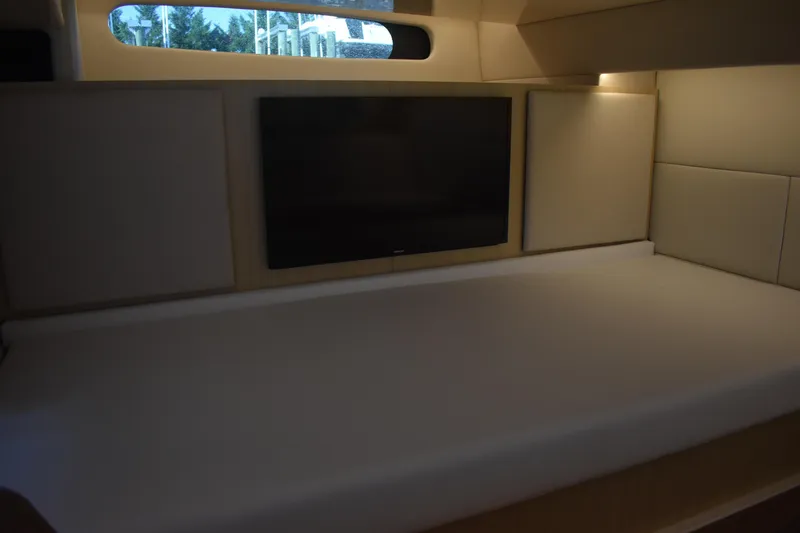 Slide: The Image of 2024 Regal 36 XO cabin interior with bed and wall-mounted TV. - 60