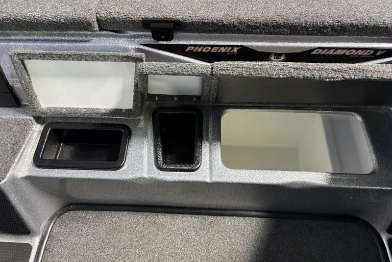 Slide: The Image of 2024 Phoenix 920 Elite boat storage compartments with carpeted interior and sleek design. - 12