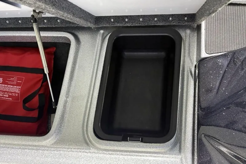 Slide: The Image of Storage compartment of 2024 Phoenix 920 Elite boat with red safety bag. - 16