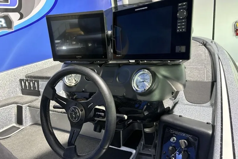 Slide: The Image of 2024 Phoenix 920 Elite boat dashboard with dual screens and steering wheel. - 21