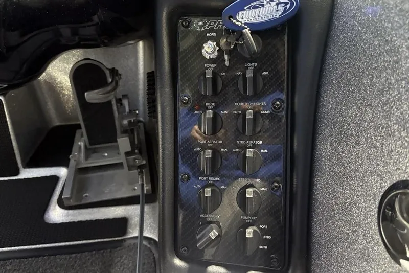 Slide: The Image of Control panel of 2024 Phoenix 920 Elite boat with various switches and key. - 22