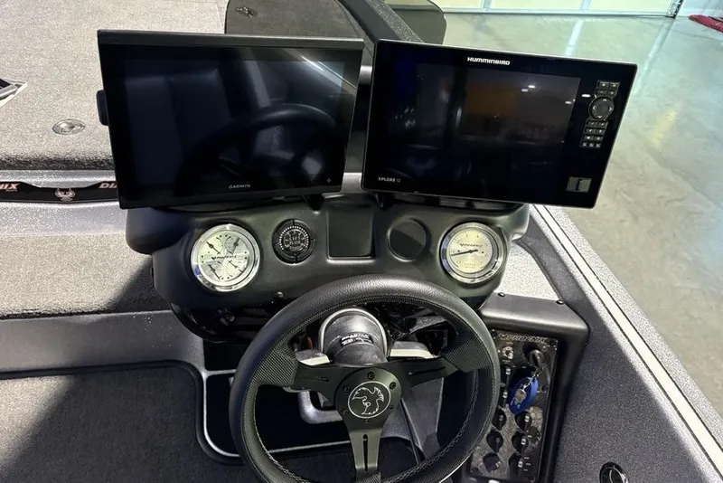 Slide: The Image of 2024 Phoenix 920 Elite dashboard with Garmin and Humminbird displays, steering wheel, and gauges. - 24