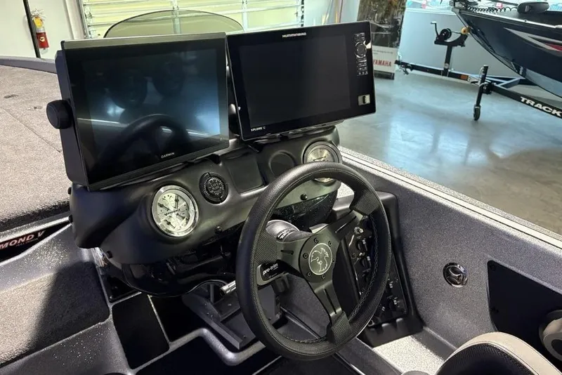 Slide: The Image of 2024 Phoenix 920 Elite boat dashboard with dual screens and steering wheel. - 25