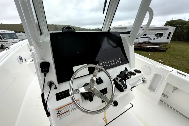 Slide: The Image of 2023 Edgewater 285CC boat dashboard with steering wheel and control panel. - 11
