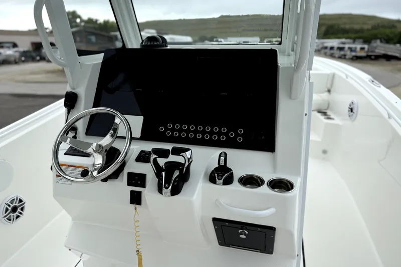 Slide: The Image of 2023 Edgewater 285CC boat console with steering wheel and controls. - 13