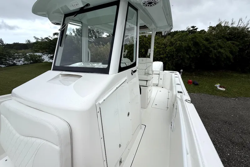 Slide: The Image of 2023 Edgewater 285CC boat with sleek white design, spacious deck, and modern console. - 14