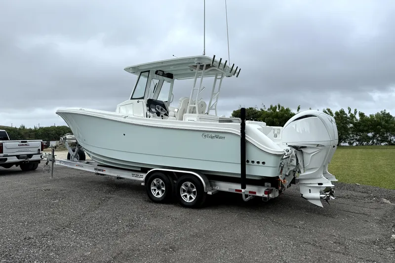 Slide: The Image of 2023 Edgewater 285CC boat on trailer, parked outdoors under cloudy sky. - 4