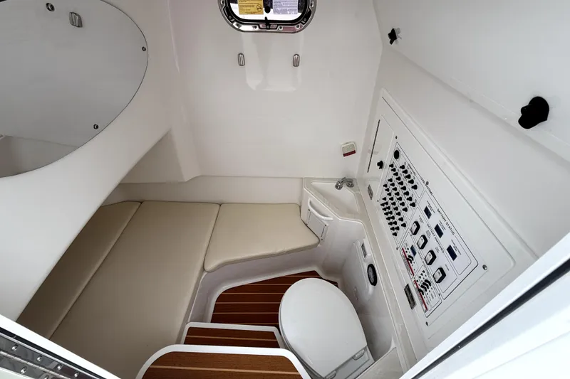 Slide: The Image of 2023 Edgewater 285CC cabin interior with seating, control panel, and toilet. - 6
