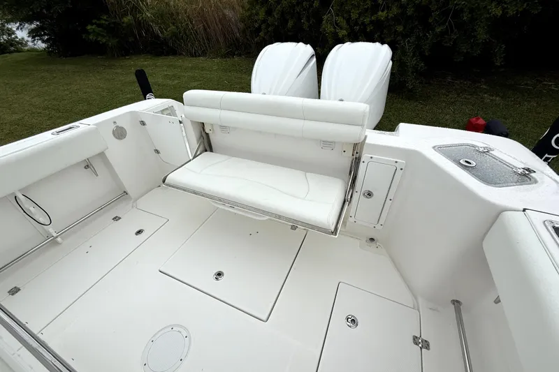 Slide: The Image of 2023 Edgewater 285CC boat interior with foldable seating and dual engines. - 8