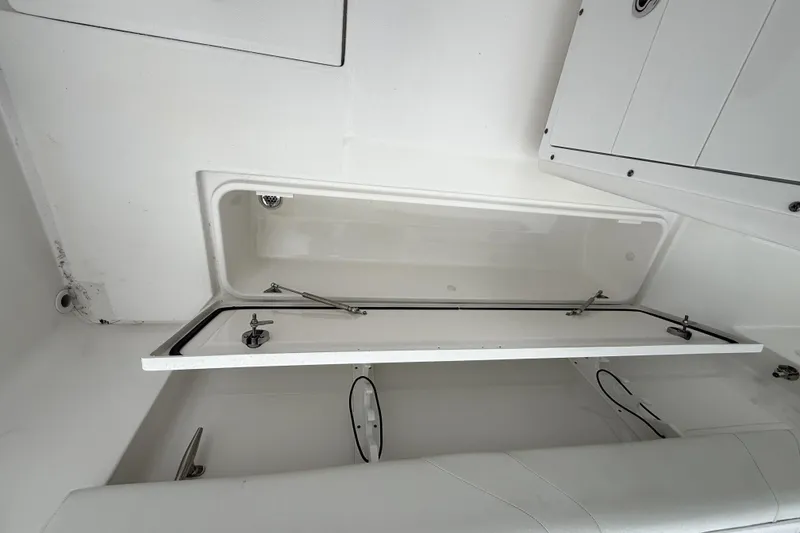 Slide: The Image of 2023 Edgewater 285CC boat storage compartment with open hatch, showcasing interior design. - 9