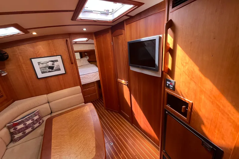Slide: The Image of Interior of 2004 Sabre 42 Hardtop Express yacht with wood paneling and cozy seating area. - 12