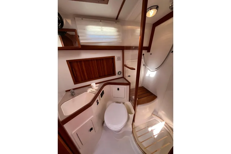 Slide: The Image of 2004 Sabre 42 Hardtop Express yacht bathroom with shower, sink, and wooden accents. - 19