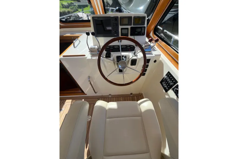 Slide: The Image of 2004 Sabre 42 Hardtop Express helm with steering wheel and navigation controls. - 8