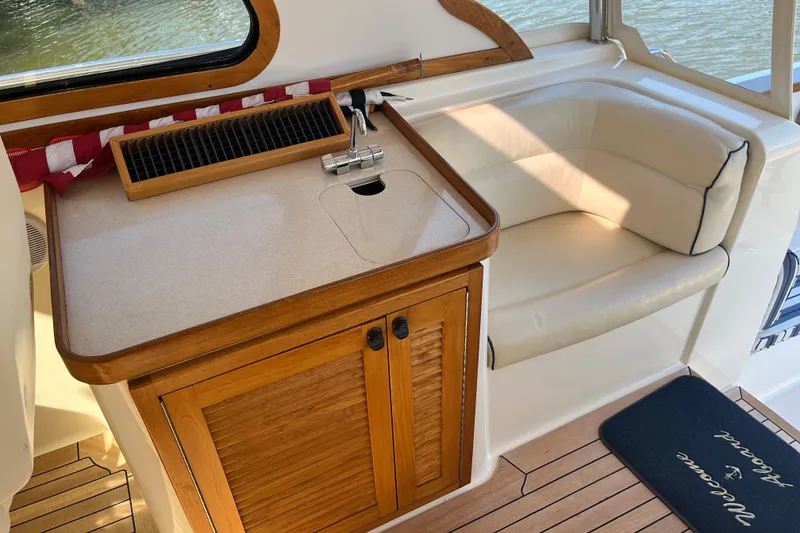 Slide: The Image of 2004 Sabre 42 Hardtop Express interior with wooden cabinetry, sink, and cushioned seating. - 9