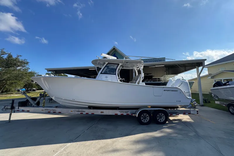 Slide: The Image of 2024 Sportsman Open 302 Center Console boat on trailer under clear blue sky. - 1