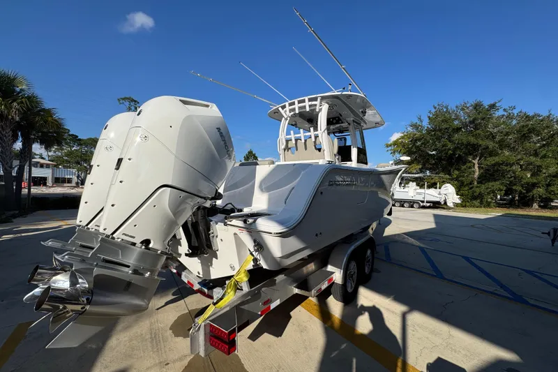 Slide: The Image of 2024 Sportsman Open 302 Center Console boat with dual outboard engines on a trailer. - 10