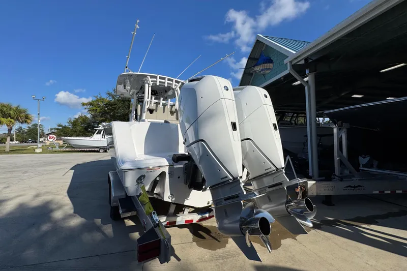 Slide: The Image of 2024 Sportsman Open 302 Center Console boat with dual outboard engines, parked outdoors. - 12