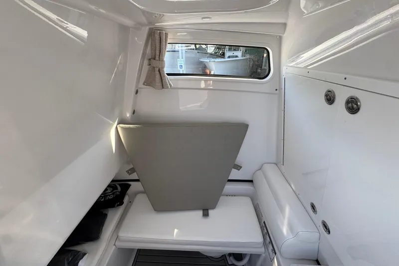 Slide: The Image of 2024 Sportsman Open 302 Center Console cabin interior with seating and window. - 26