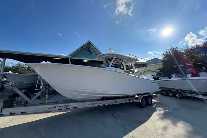 Slide: The Image of 2024 Sportsman Open 302 Center Console boat on trailer under sunny sky. - 3