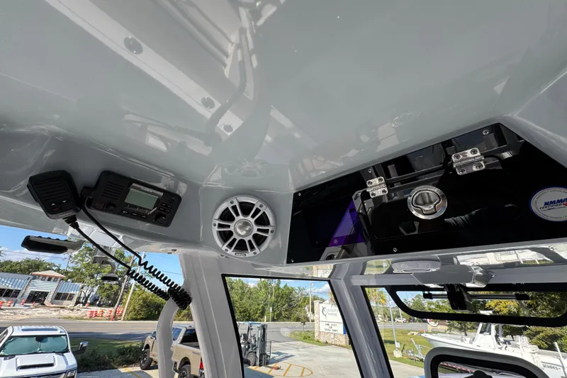 Slide: The Image of 2024 Sportsman Open 302 Center Console interior with radio, speaker, and storage compartment. - 33