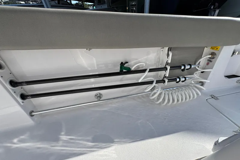 Slide: The Image of 2024 Sportsman Open 302 Center Console boat interior with rod holders and coiled hose. - 37