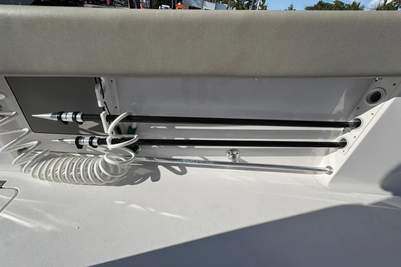 Slide: The Image of 2024 Sportsman Open 302 Center Console boat interior with rod holders and coiled hose. - 38
