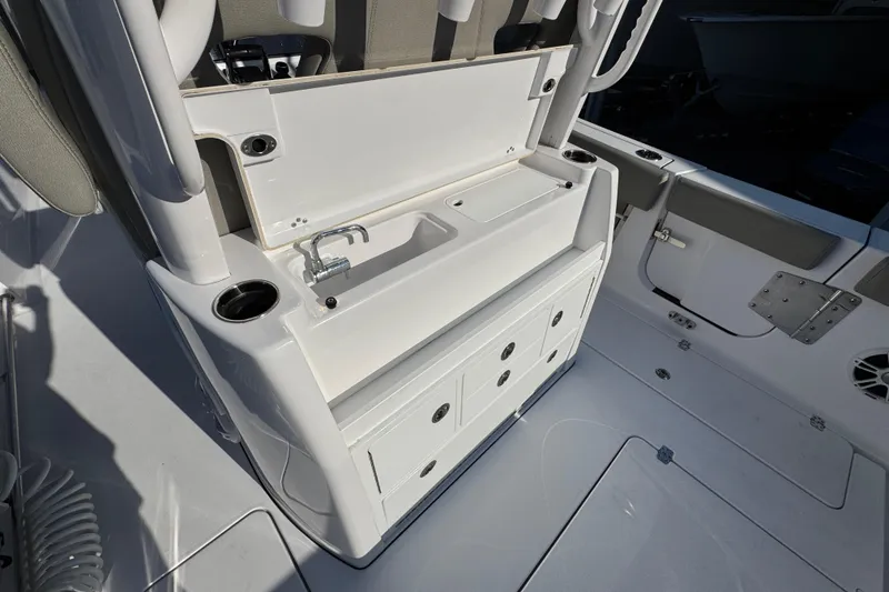 Slide: The Image of 2024 Sportsman Open 302 Center Console boat interior with sink and storage drawers. - 44