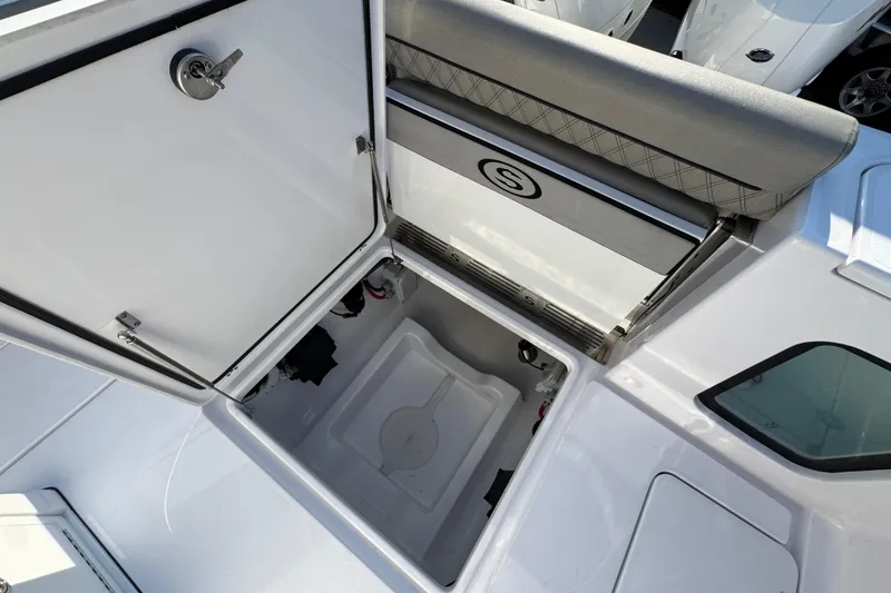 Slide: The Image of 2024 Sportsman Open 302 Center Console storage compartment with open hatch and cushioned seat. - 45