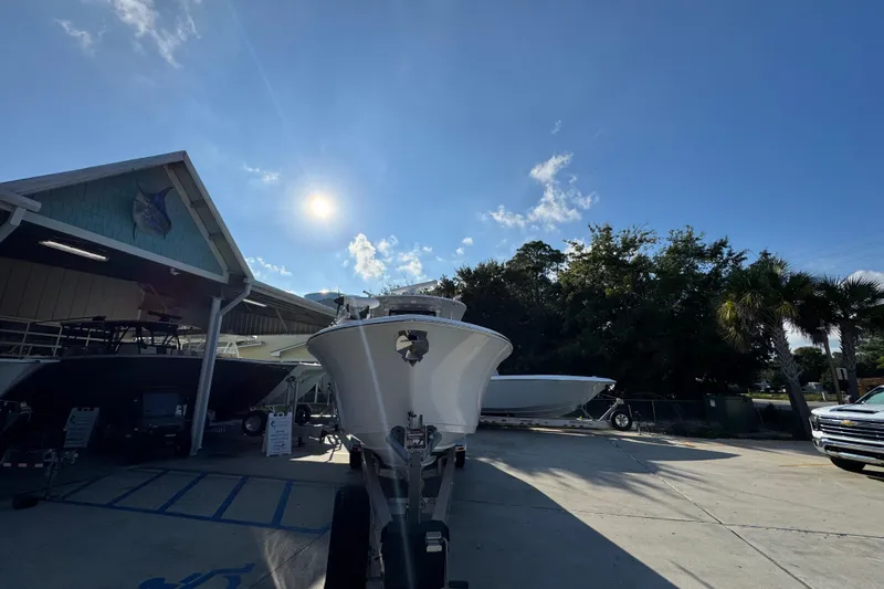 Slide: The Image of 2024 Sportsman Open 302 Center Console boat displayed outdoors under a clear blue sky. - 5