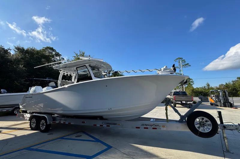 Slide: The Image of 2024 Sportsman Open 302 Center Console boat on trailer under clear blue sky. - 7