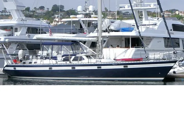 The Image of 2006 Tayana 58 Deck Salon yacht docked at marina, surrounded by other boats. - 0
