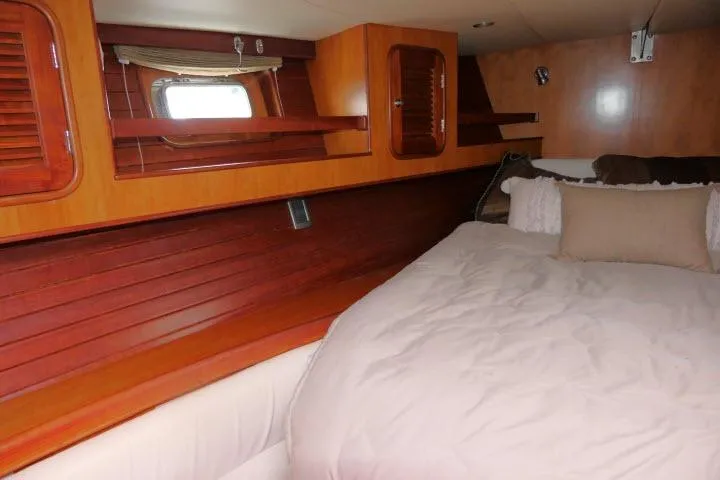 Slide: The Image of Cozy bedroom in 2006 Tayana 58 Deck Salon yacht with wooden interior and plush bedding. - 21