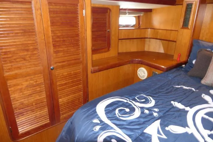 Slide: The Image of Luxurious 2006 Tayana 58 Deck Salon interior with nautical-themed bedding and elegant wood finish. - 30