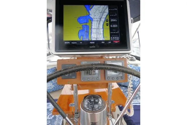 Slide: The Image of 2006 Tayana 58 Deck Salon sailboat with blue canopy in marina setting. - 46