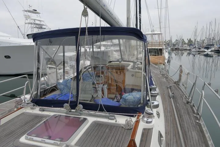 Slide: The Image of 2006 Tayana 58 Deck Salon yacht docked, showcasing sleek deck design and marina setting. - 49