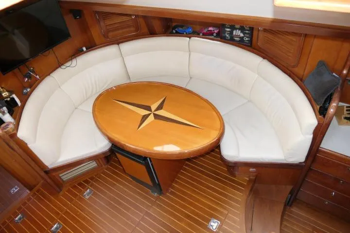 Slide: The Image of Luxurious 2006 Tayana 58 Deck Salon interior with elegant wood finish and curved seating. - 6
