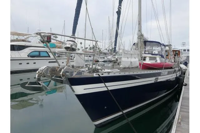Slide: The Image of 2006 Tayana 58 Deck Salon yacht docked in marina, surrounded by other boats. - 78