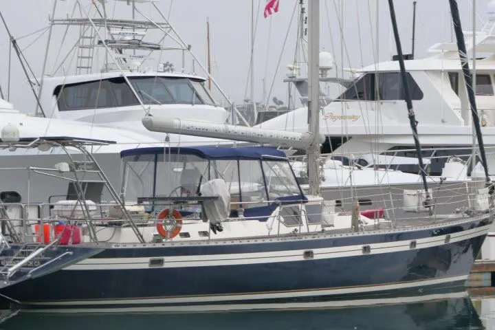 Slide: The Image of 2006 Tayana 58 Deck Salon sailboat docked at marina with American flag. - 79