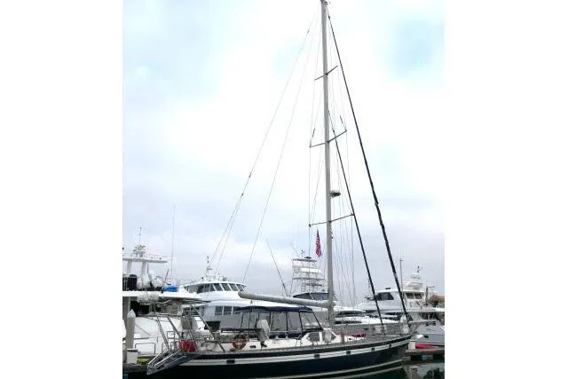 Slide: The Image of 2006 Tayana 58 Deck Salon yacht docked in a marina, surrounded by other boats. - 81