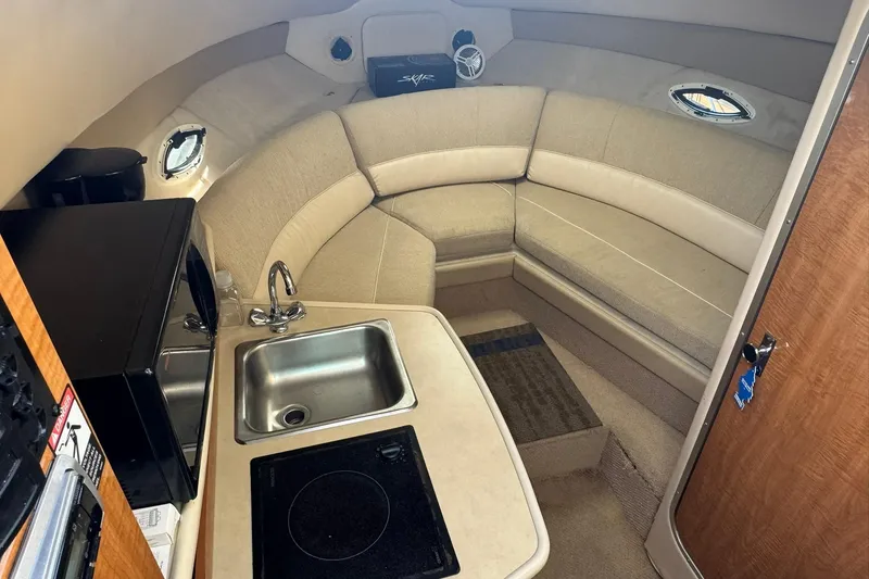 Slide: The Image of 2003 Maxum 2400 SCR boat interior with white seating and wooden table. - 11