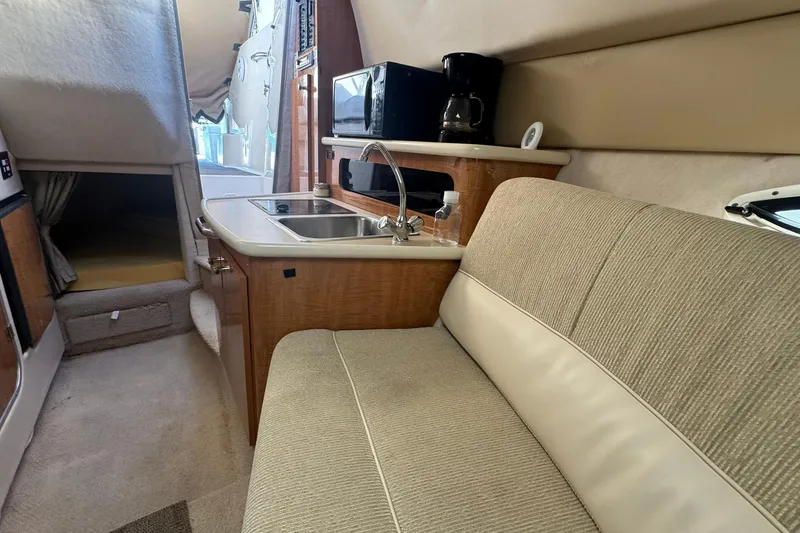 Slide: The Image of 2003 Maxum 2400 SCR boat cockpit with steering wheel and control panel, docked by the water. - 17