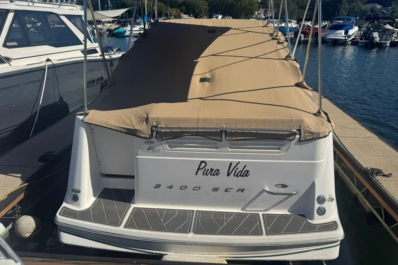 Slide: The Image of 2003 Maxum 2400 SCR boat docked at marina under clear blue sky. - 2
